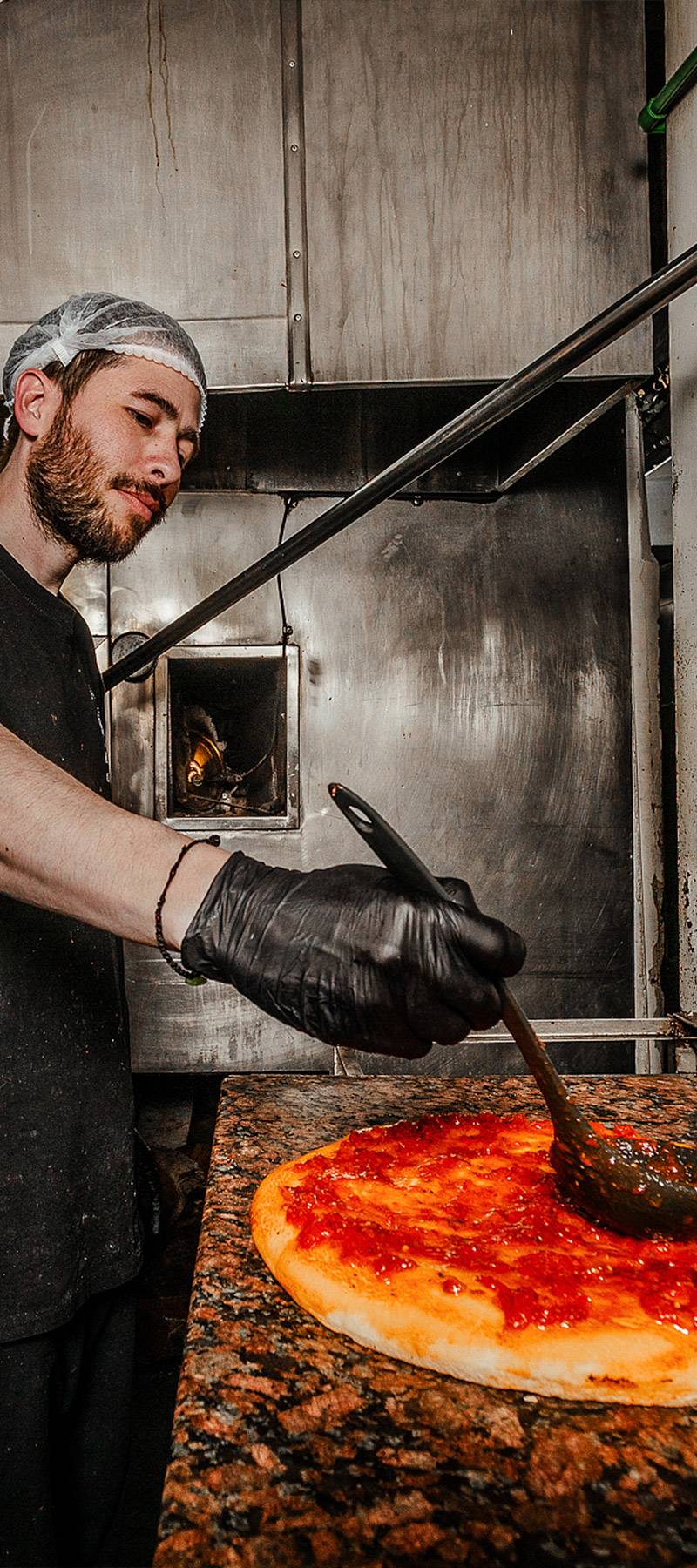 Saucing the pizza.