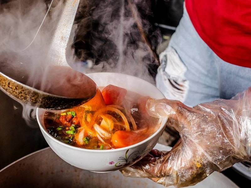 Ladling the broth.