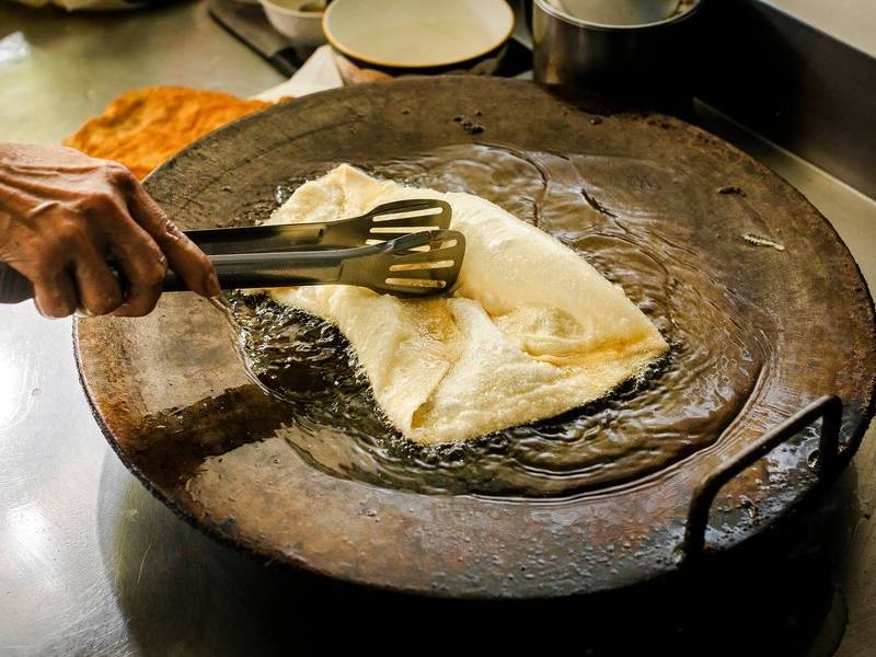 Frying the roti.